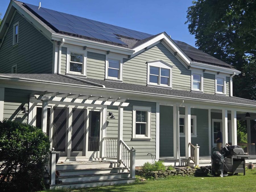 Freshly painted sage green farmhouse exterior with white trim