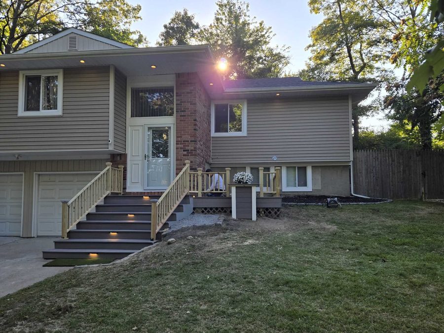 Repainted split-level home exterior with new deck staining and lighting