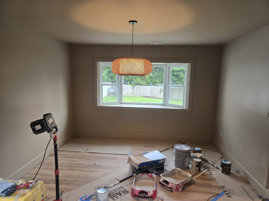 Freshly painted dining nook with bay window, mid-project with paint supplies
