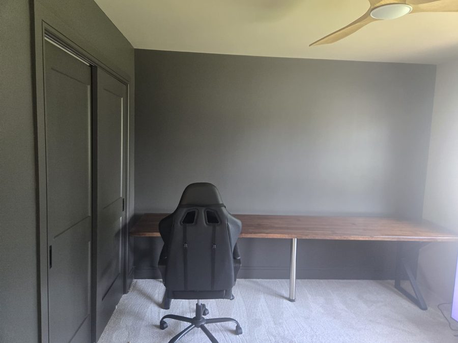 Freshly painted home office with a bold charcoal accent wall and built-in closet